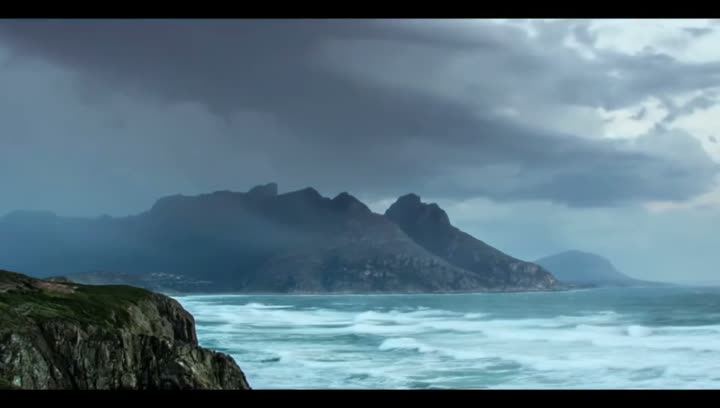 Waves breaking on a rocky coast under dark clouds