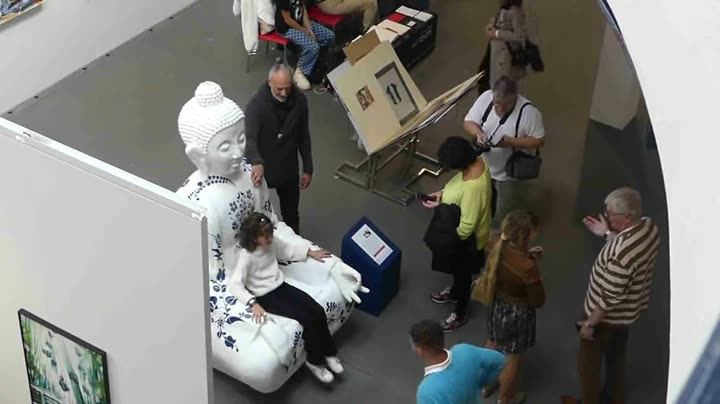Visitors around a statue in a museum, filmed from above