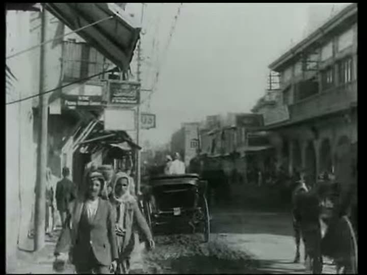 An old black-and-white film of a busy street