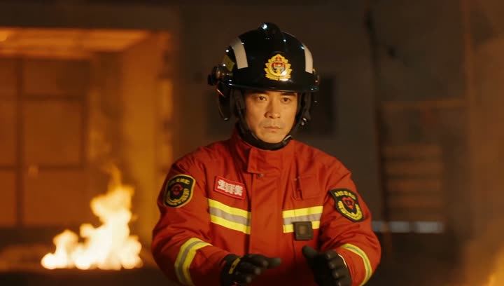 A firefighter in front of flames