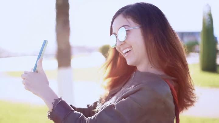 A woman in sunglasses taking a selfie